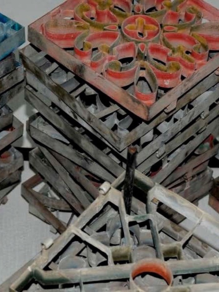 Stacked metal tile moulds stained with coloured pigment