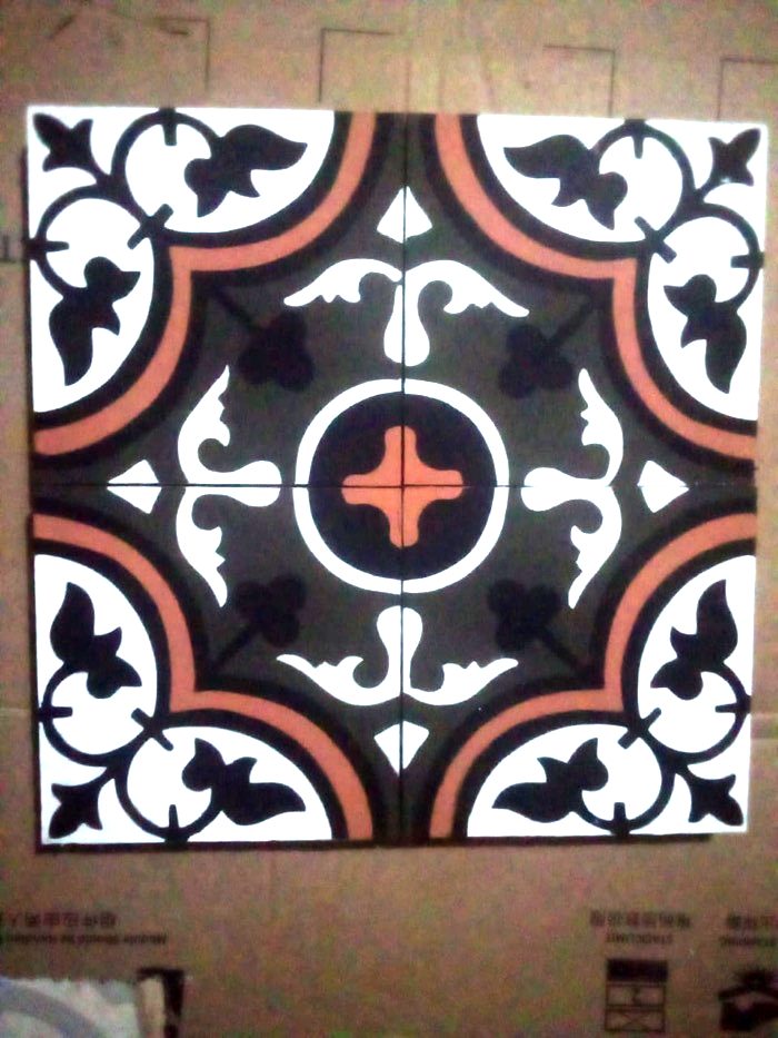 A finished heritage pattern tile in black, white and terracotta