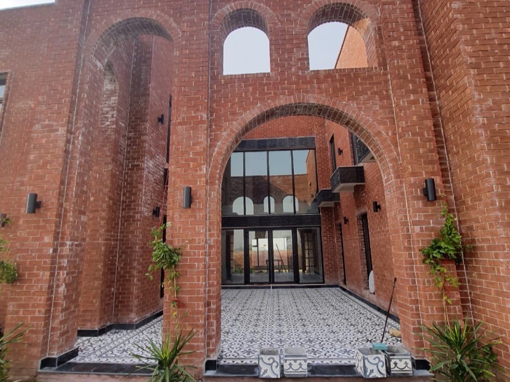 Brick villa entrance with a patterned cement tile courtyard
